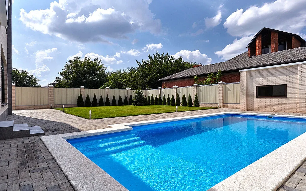 Piscine avec membrane armée RENOLIT ALKORPLAN 2000 Bleu Adriatique, eau bleu profond dans un jardin clôturé