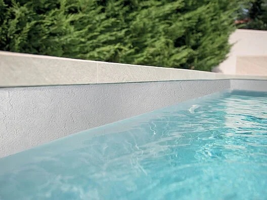Piscine avec membrane armée RENOLIT ALKORPLAN Relief Gris clair, paroi texturée gris perle et eau turquoise