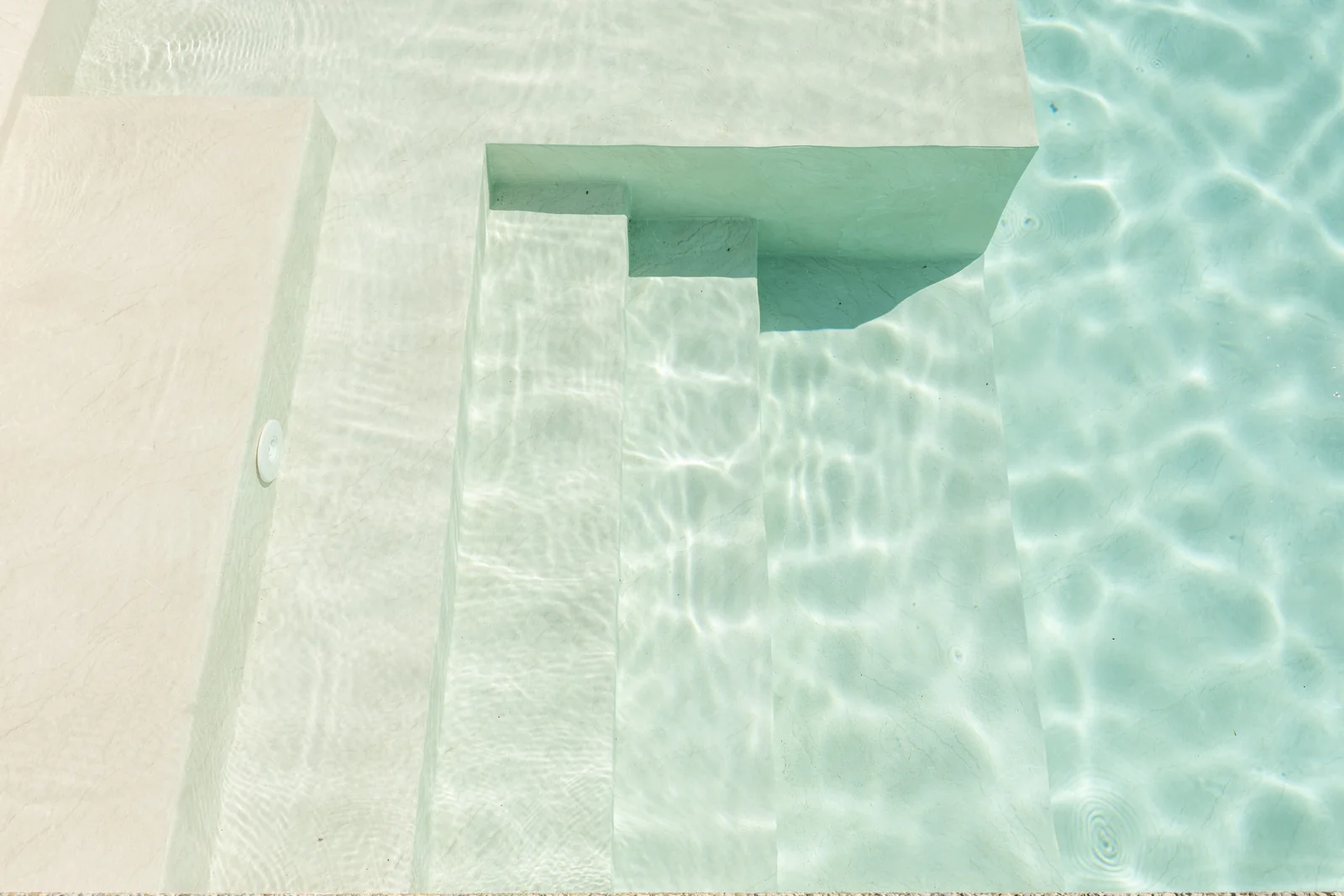 Marches de piscine avec membrane armée RENOLIT ALKORPLAN Vogue Nordic, effet pierre claire et eau turquoise cristalline